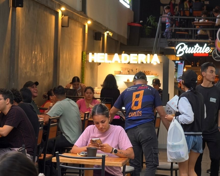Mesas llenas frente al letrero HELADERÍA una noche de fin de semana