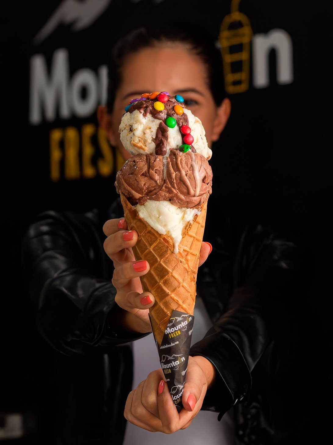 Barquilla de tres bolas con toppings frente al logo de Mountain Fresh