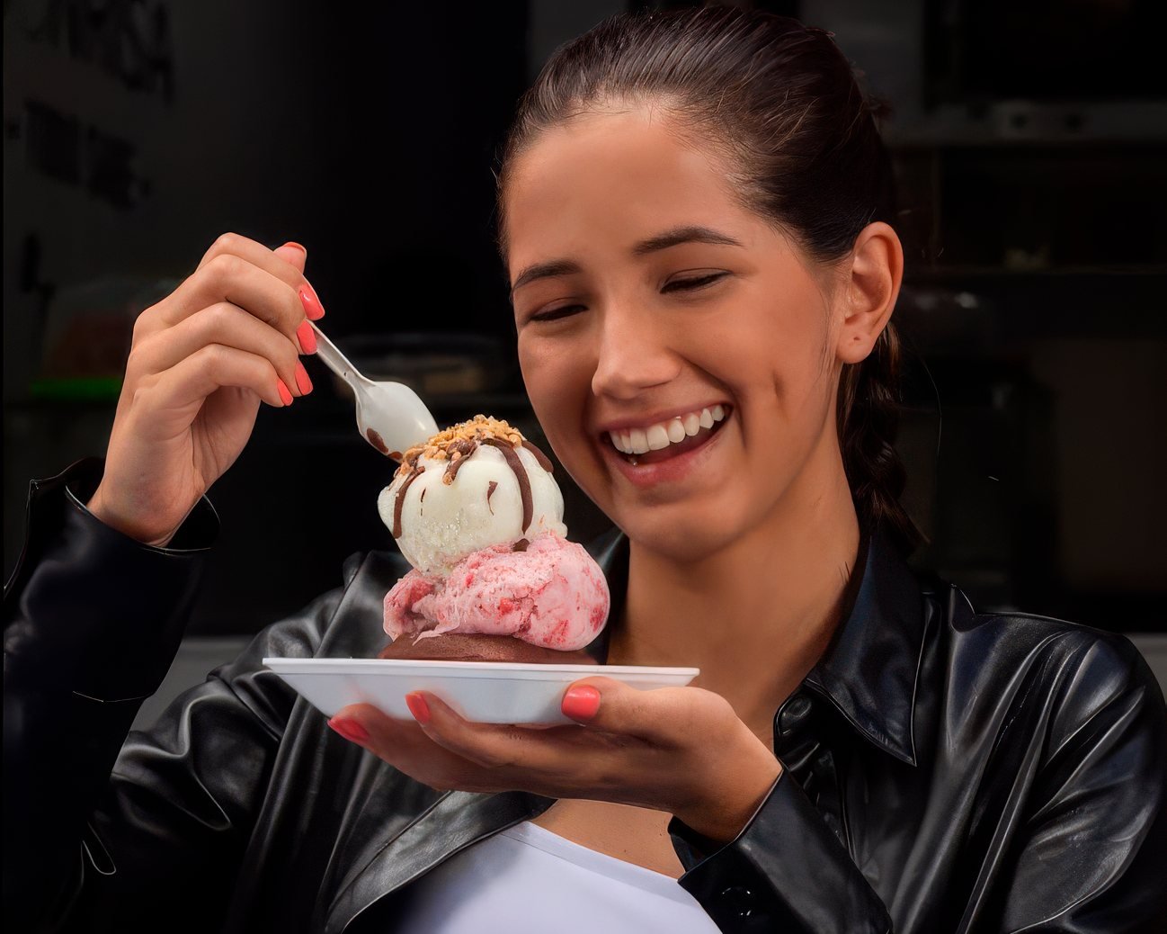 Clienta sentada con un plato de helado de fresa y chocolate